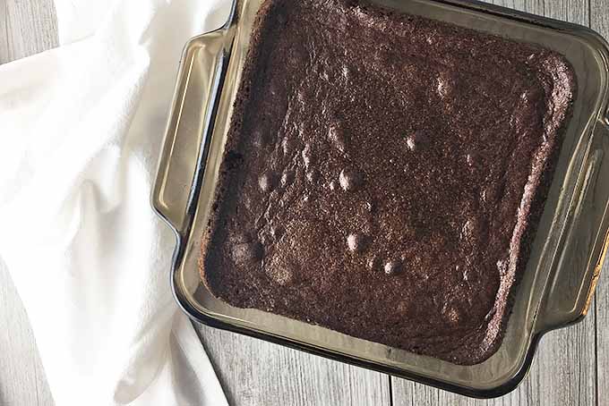 Horizontal image of cooked brownie in a square pan.