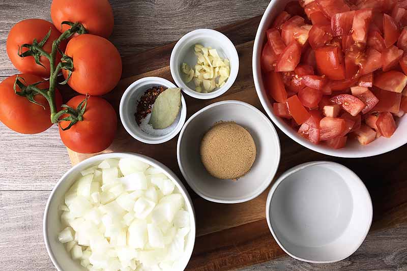 Horizontal image of ingredients in white bowls on a wooden cutting board.