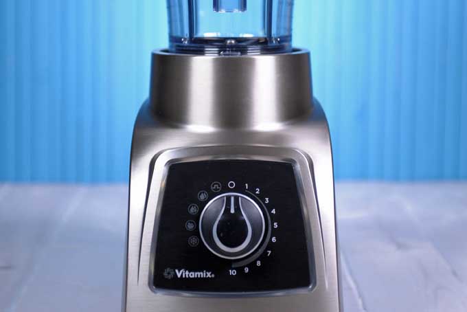 The bottom half of a Vitamix S55 blender on a blue background.