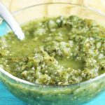 A clear mixing bowl full of a traditional salsa verde recipe.