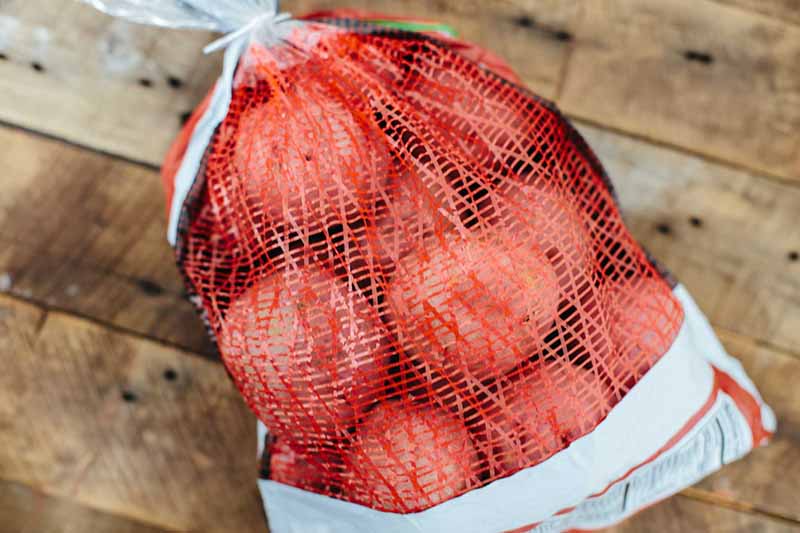 Horizontal image of a red bag of potatoes.