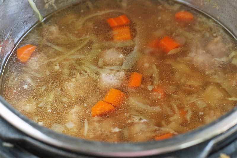 Carrots, cabbage, bratwurst, and beer, in a slow cooker.