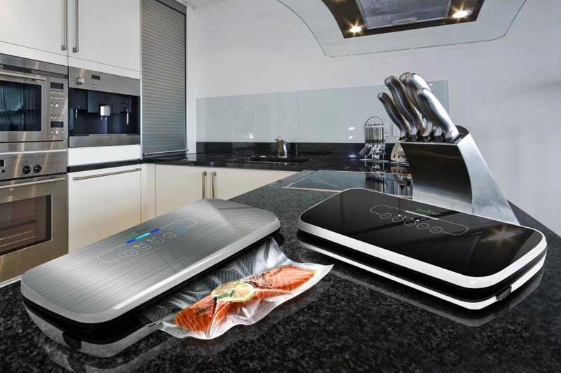 The NutriChef PKVS18SL Compact Vacuum Sealer sitting on a granite coutnertop in a higher end kitchen.