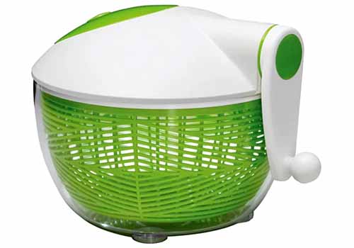Green and white plastic Starfrit salad spinner, isolated on a white background.