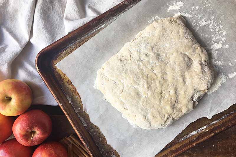 Horizontal image of a rectangular piece of dough on a baking sheet lined with parchment.