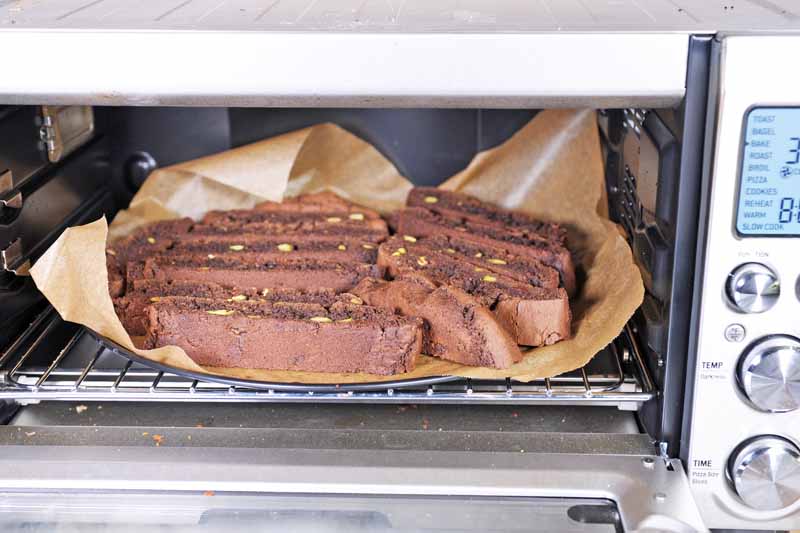 Close up view of a batch of double chocolate biscotti cookies being baked in a convection toaster oven.