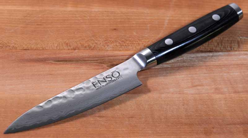 An Enso HD Hammered Damascus 4.75-inch Petty Utility Knife on a maple cutting board.