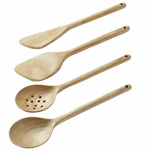 Four wooden cooking utensils, isolated on a white background.