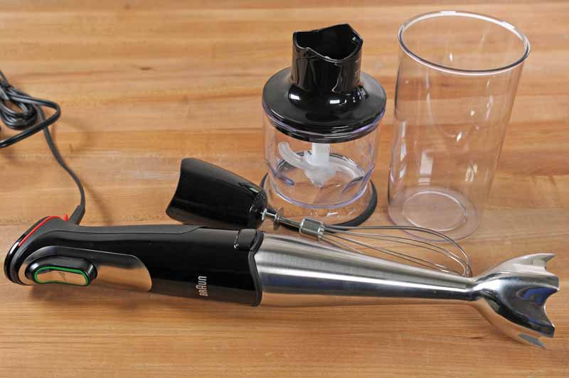 Braun MQ725 Multiquick Hand Blender with all included attachments on a maple wooden cutting board.