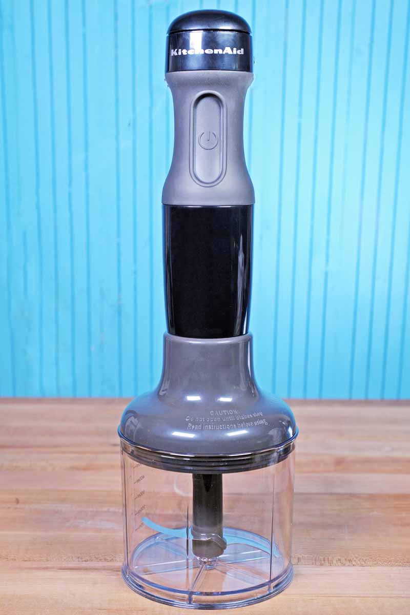 The KitchenAid KHB2351 Motor Base attached to the Food Processor Attachment. On a blue wooden background.