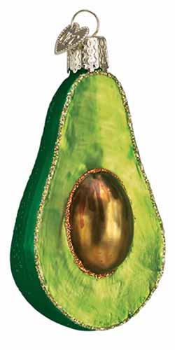 Vertical image of a blown glass avocado ornament, isolated on a white background.
