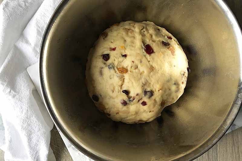 Horizontal image of risen dough in a metal bowl.