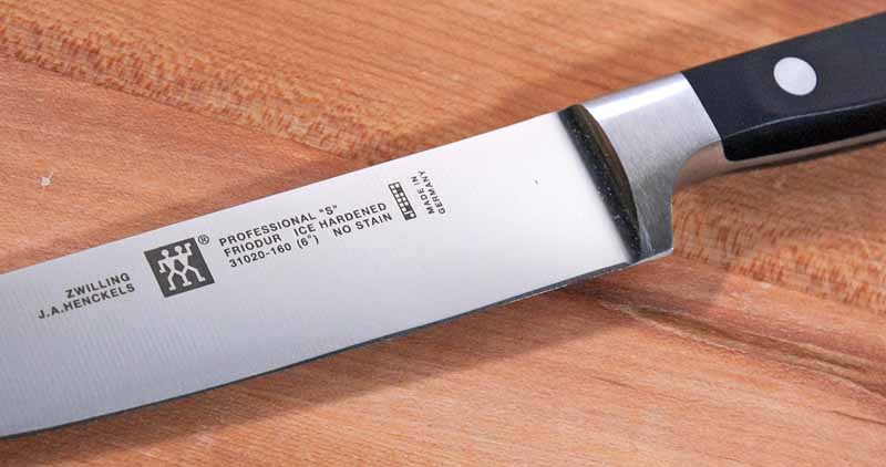 A close up of the blade, bolster, and laser etched logo of the ZWILLING J.A. Henckels Professional S 6-inch Utility.