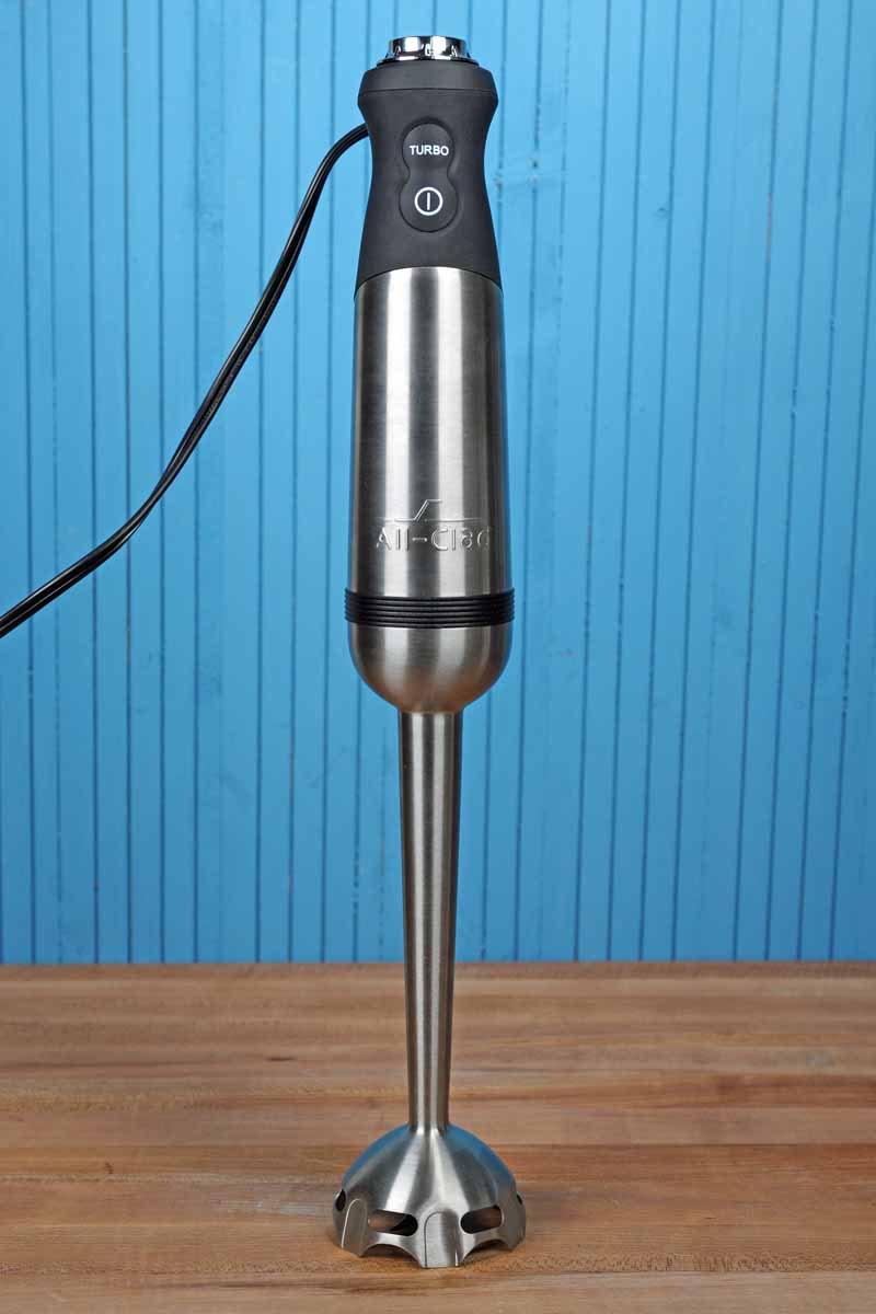 All-Clad KZ750D Stainless Steel Immersion Blender on a blue painted wooden background.