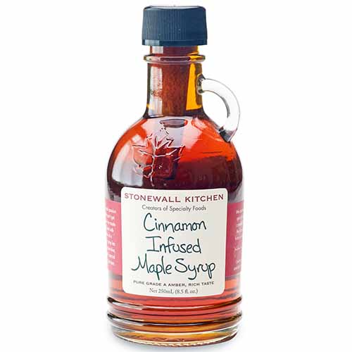 Square image of a glass bottle of cinnamon-infused maple syrup, isolated on a white background.