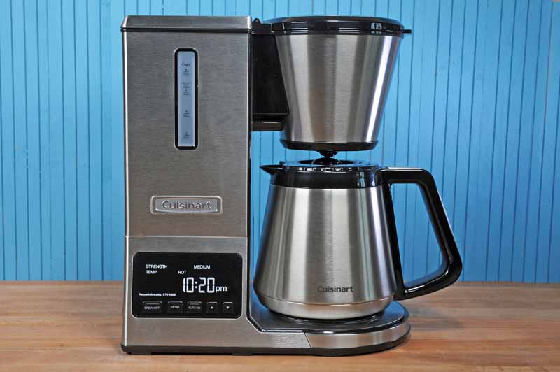 The Cuisinart CPO-850 Pour Over Coffee Brewer with Stainless Steel Thermal Carafe sitting on maple butcher block surface with a blue background.
