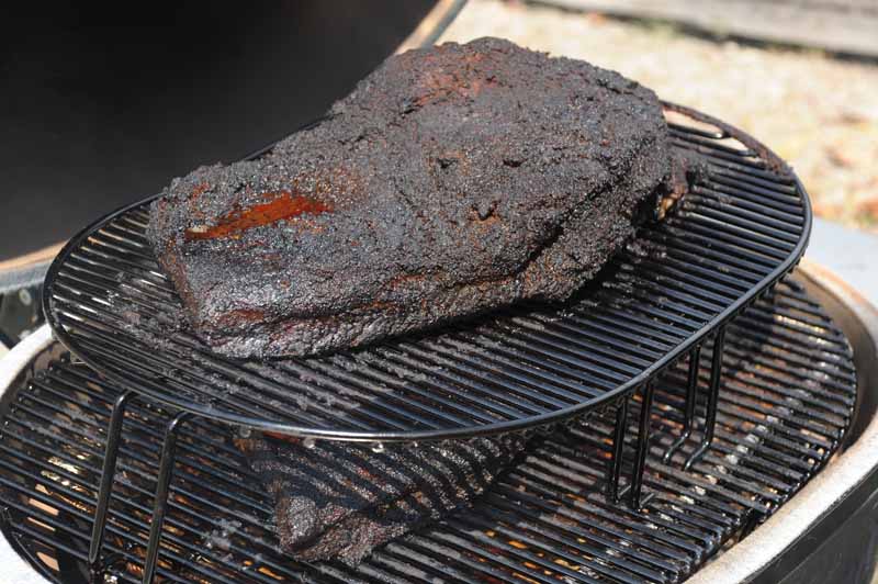 Closeup shot of two briskets being smoked on the Primo Oval XL 400 Ceramic Kamado Grill.