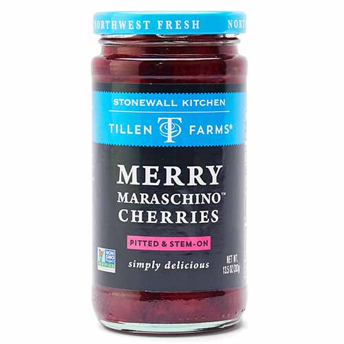 A jar of maraschino cherries with a black, blue, and pink label with white lettering and a blue lid, isolated on a white background.