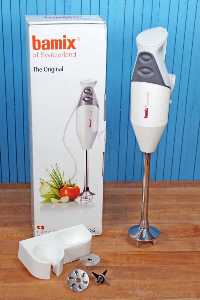 Bamix Pro-2 G200 Professional Series Immersion Hand Blender on a maple wooden butcher block surface and blue painted wall background.