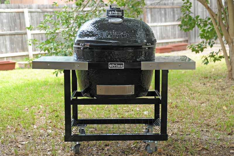 The Primo XL 400 Ceramic Kamado Grill and Smoker in a backyard setting.