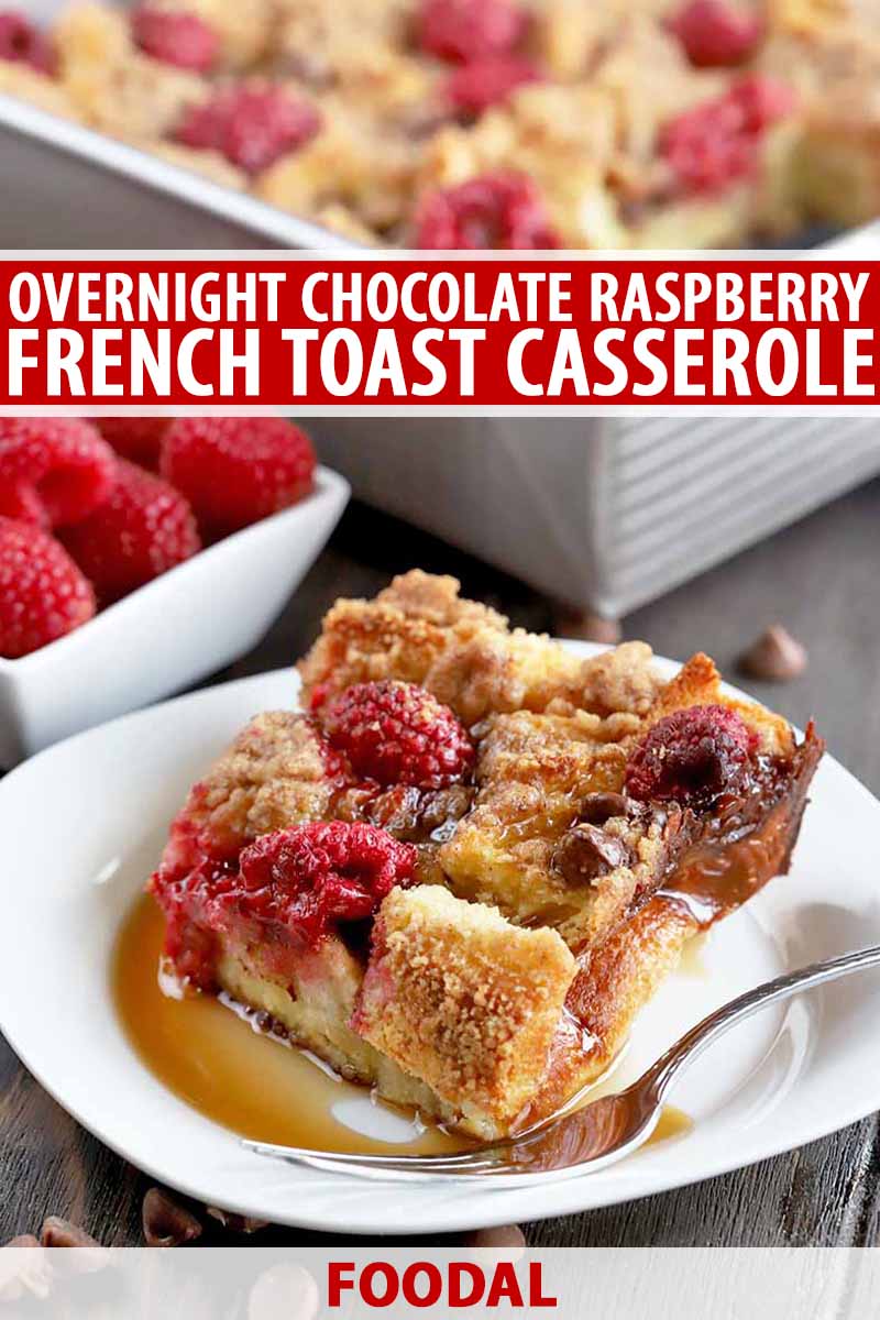 Vertical head-on shot of a white plate of French toast casserole with a fork and drizzled with maple syrup, with a small, square, white dish of fresh berries and more of the casserole in a matal baking pan in soft focus in the background, on a dark brown wood surface, printed with red and white text.