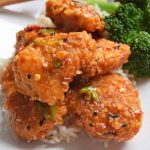 Baked and lightened up General Tso's chicken on a white ceramic plate.