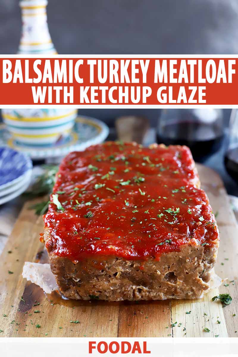 Vertical image of a whole meatloaf topped with ketchup and herbs on a wooden cutting board, with text on the top and bottom of the image.
