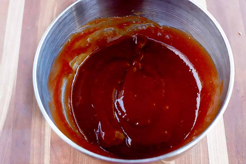 Horizontal image of a metal bowl with a ketchup mixture.