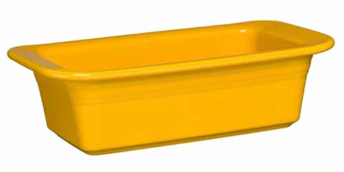 A yellow ceramic loaf pan isolated on a white background.