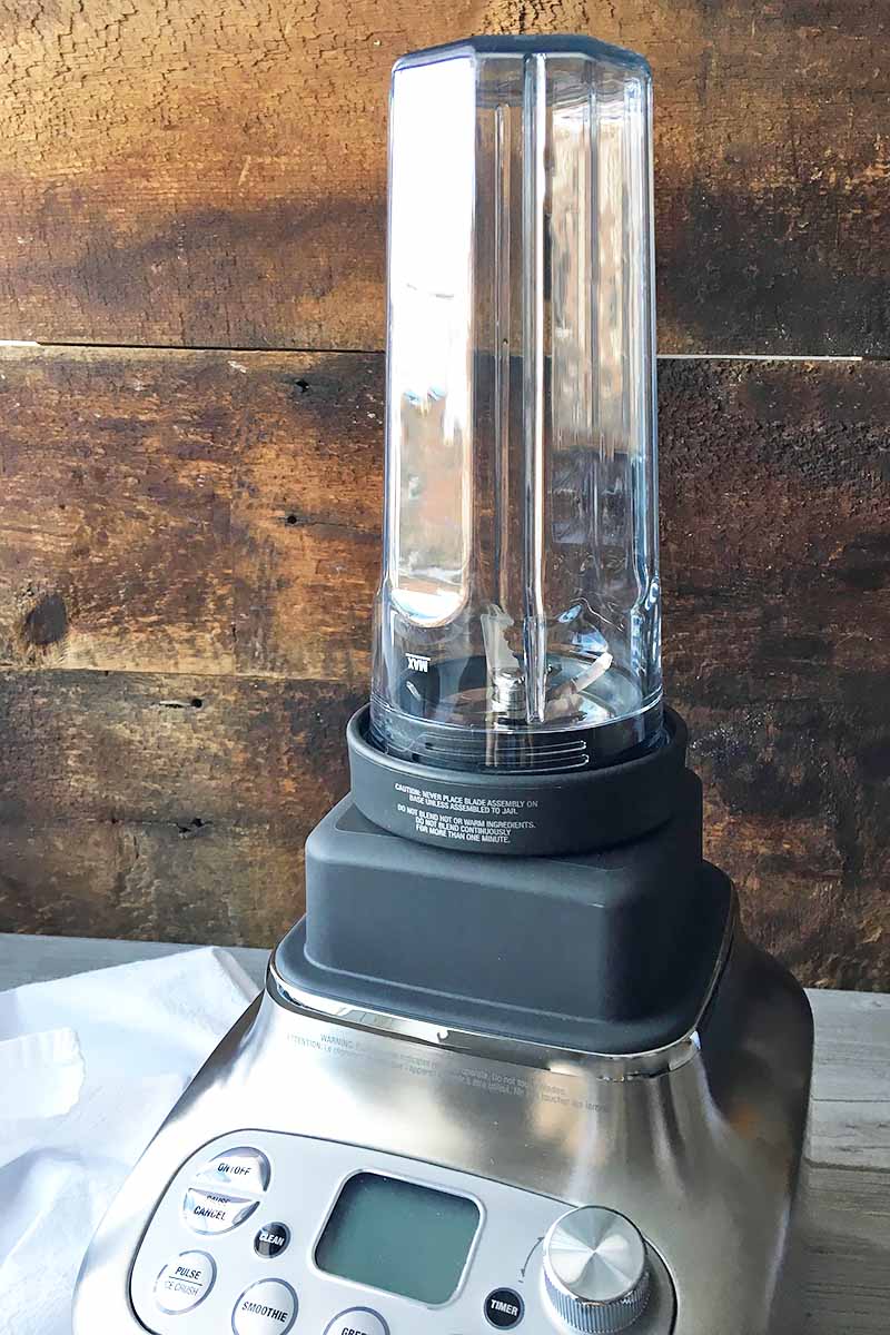 Vertical image of a personal blender accessory on a blender base.