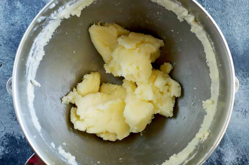 Top down view of the bowl of stand mixer shower a light and fluffy whipped butter and sugar combination.