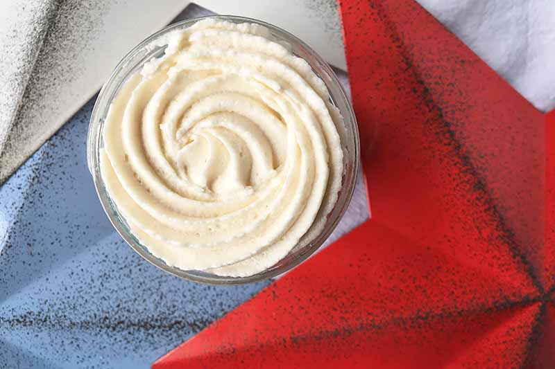 Horizontal image of the top of a decorated dessert with icing next to white, red, and blue stars.