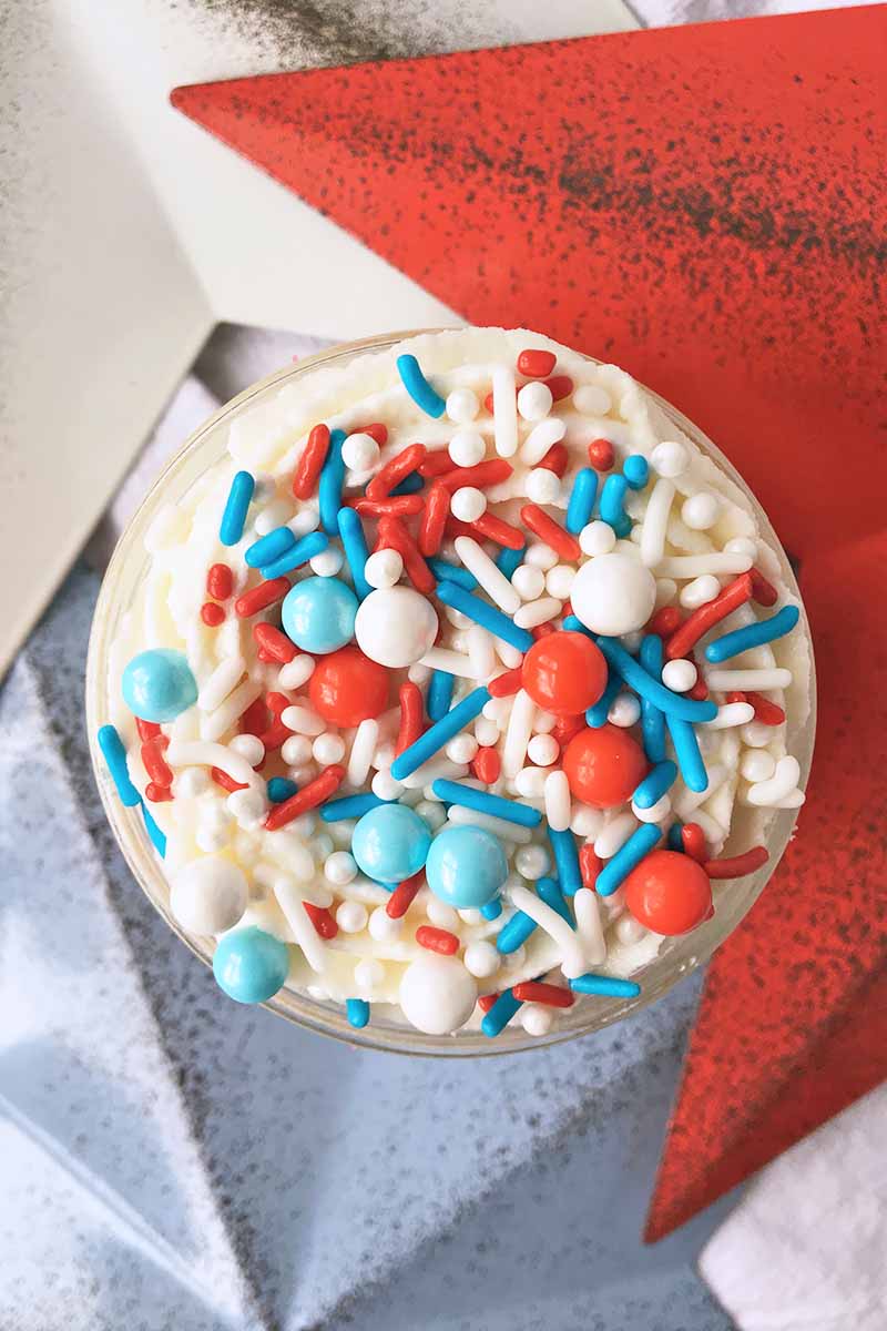 Vertical image of the top of a decorated dessert next to a red, white, and blue star.