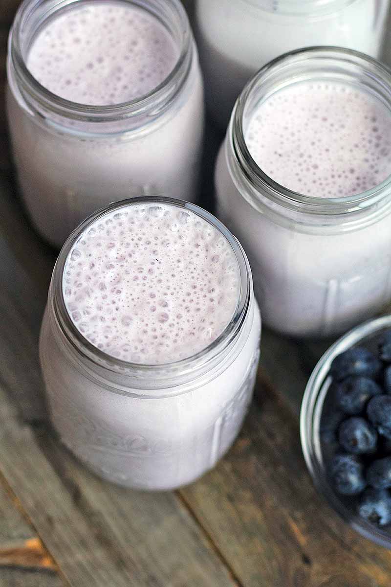 Vertical image of glass jars filled with a light purple smoothie.