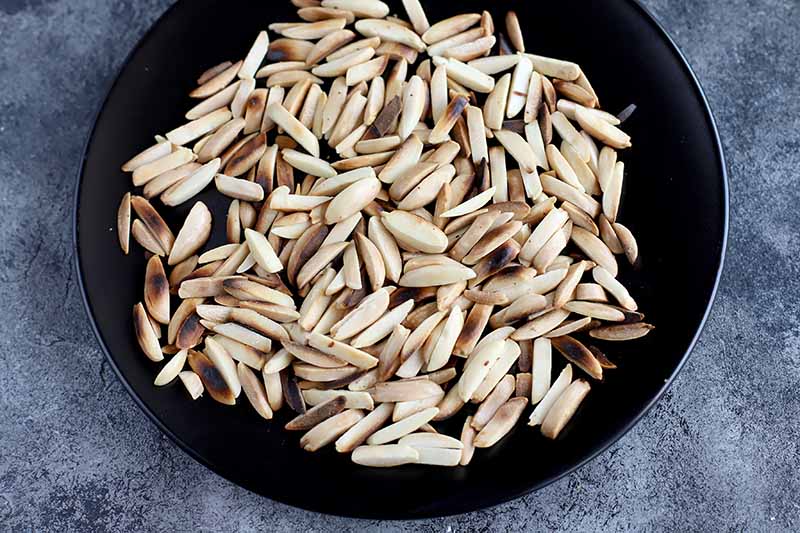 Horizontal image of a pan with toasted slivered almonds.