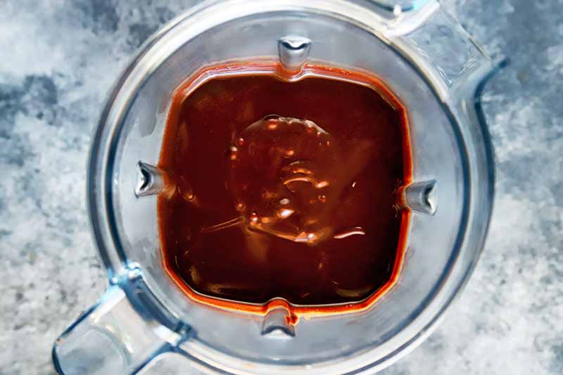 Horizontal image of a dark cocoa liquid mixture in a blender.