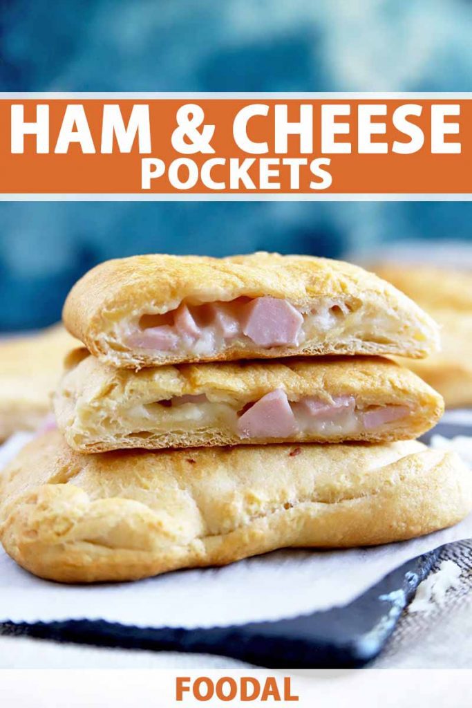 Vertical image of savory ham and cheese pastries, with three pieces stacked in the foreground, the top two sliced in half to show the filling inside, and more in soft focus in the background, on a piece of white parchment paper on top of a slate surface, with a blue and white backdrop, printed with orange and white text in the top third and at the bottom of the frame.