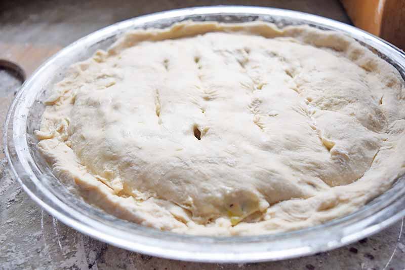 Horizontal image of an unbaked shaped pie in a pie dish.
