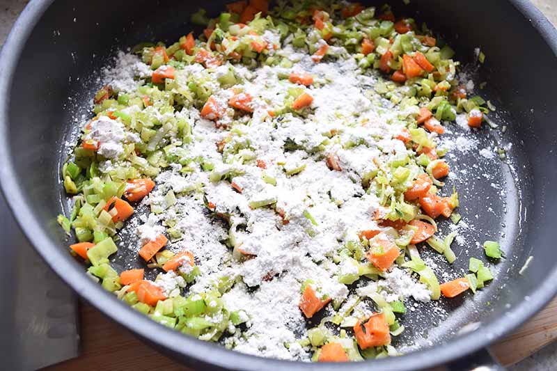 Horizontal image of a pan with flour and vegetables.