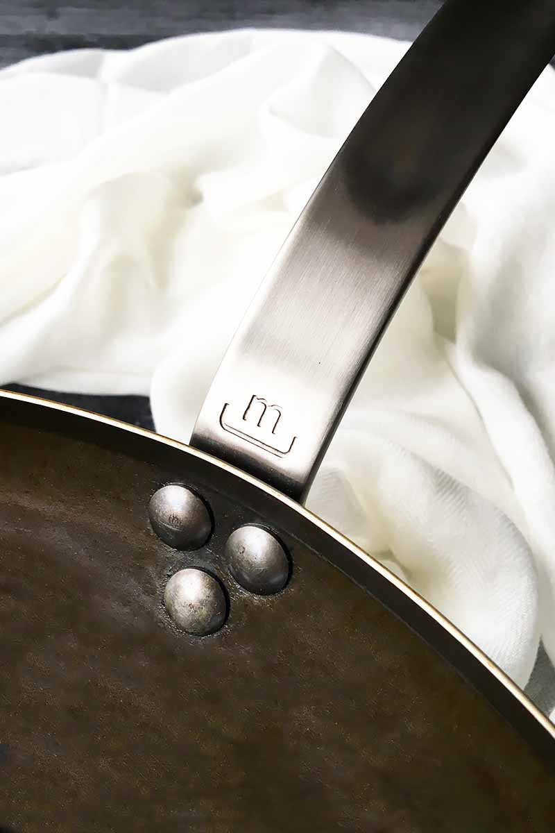 Vertical close-up image of the Made In handle of a wok.