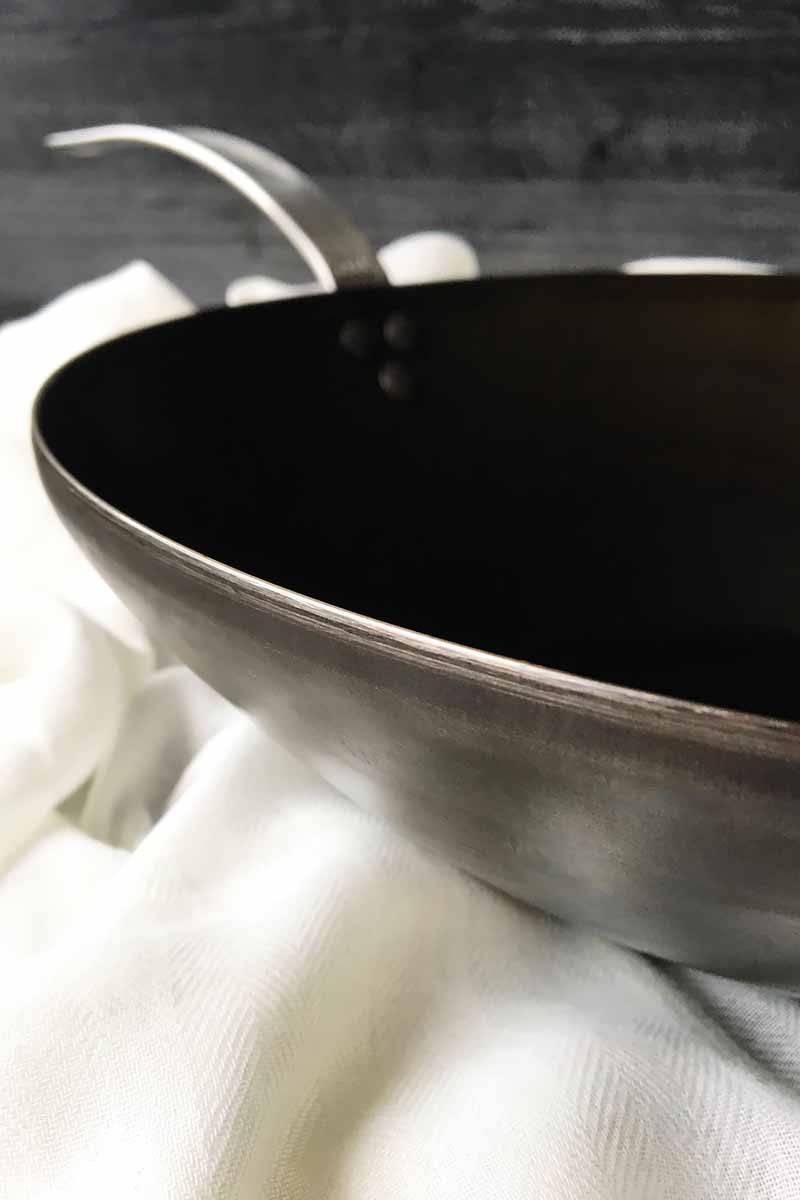 Vertical close-up image of a wok pan.
