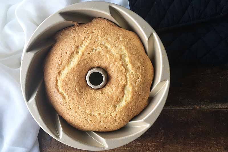 Horizontal image of a baked cake in a bundt pan.