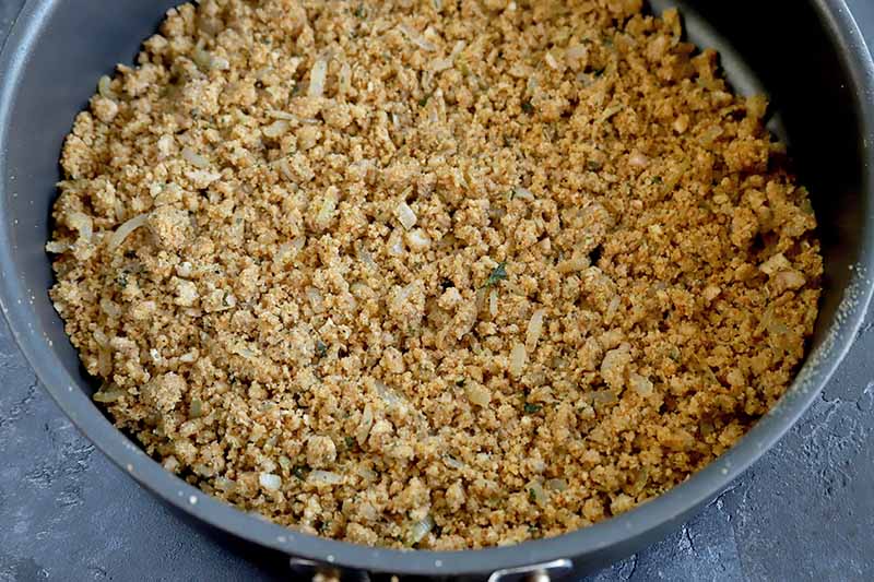 Horizontal image of a breadcrumb stuffing mixture in a frying pan.
