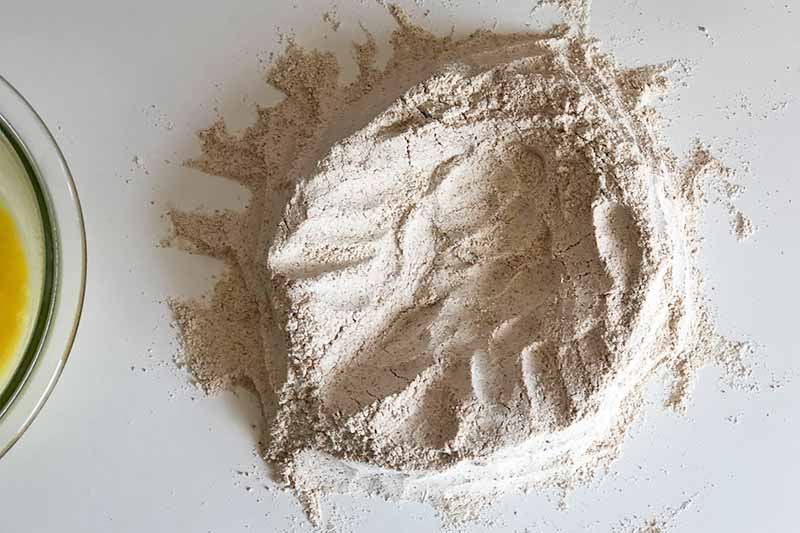 Horizontal image of a mound of flour with a well in the center.