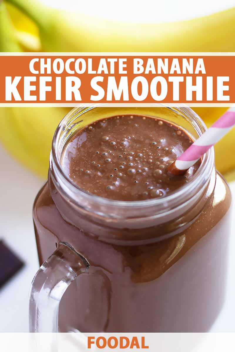Vertical image of a glass jar with a handle filled with a dark brown smoothie and a straw, with bananas in the background and text on the top and bottom of the image.