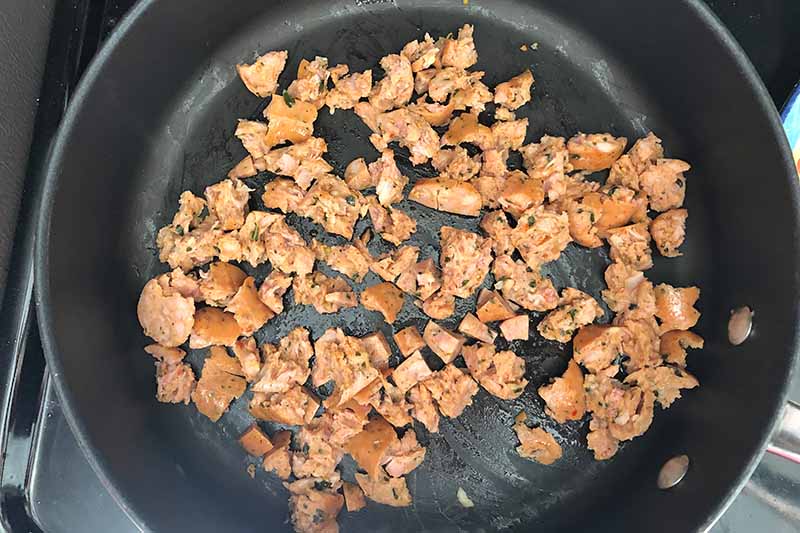 Horizontal image of a pan with crumbled chicken sausage.