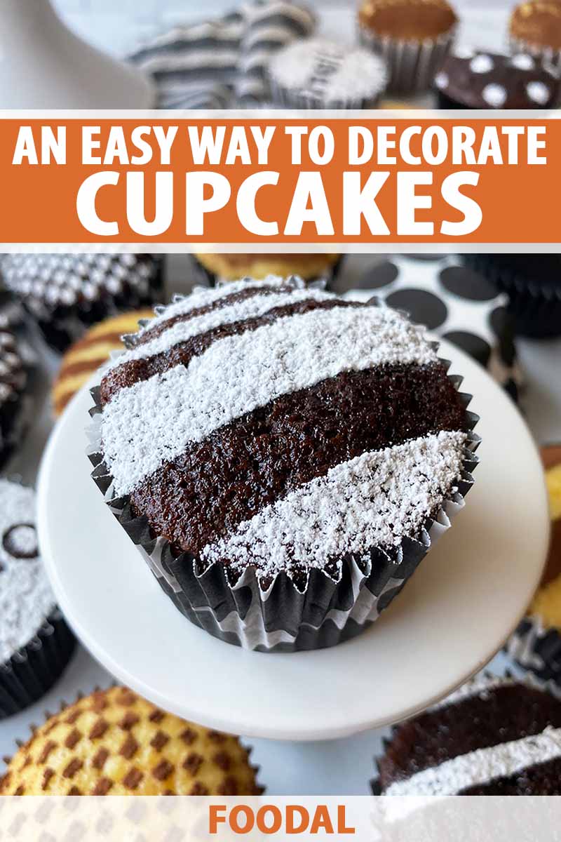 Vertical image of a chocolate cupcake with powdered sugar decorations on a white stand in front of my decorated cupcakes, with text on the top and bottom of the image.