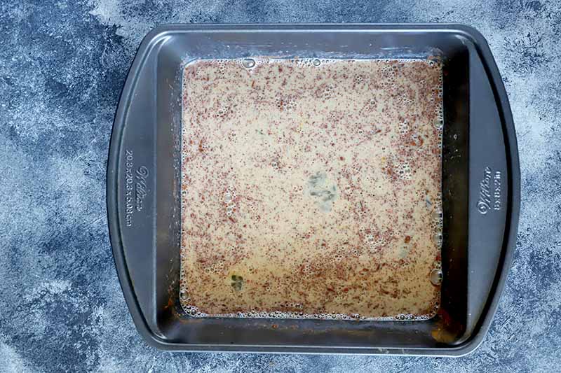 Horizontal image of a square pan with a milk and spice mixture.