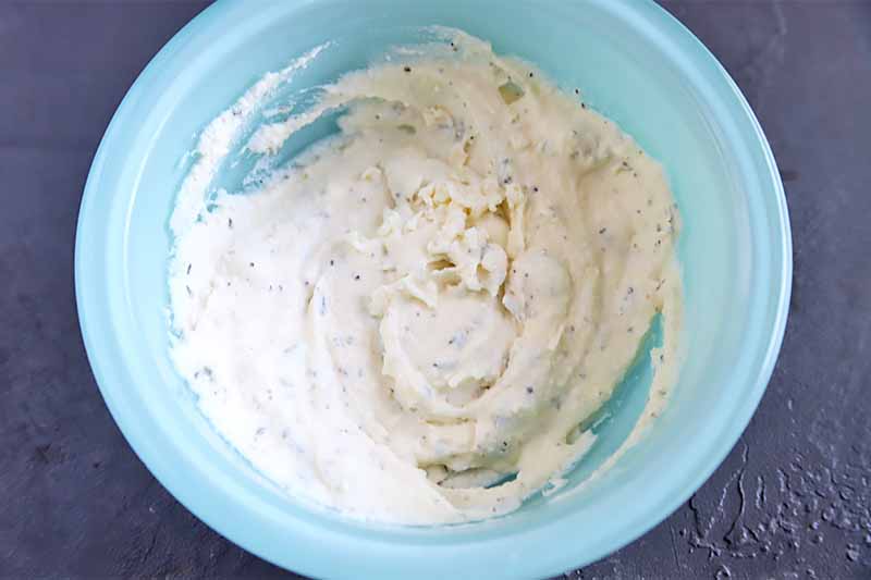 Horizontal image of a blue bowl with a creamy cheese mixture.