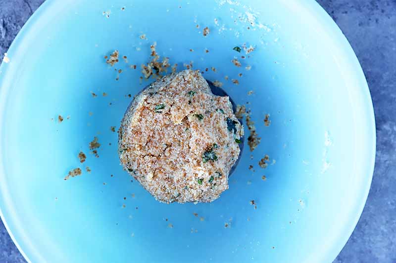 Horizontal image of a blue bowl with a mound of dough.